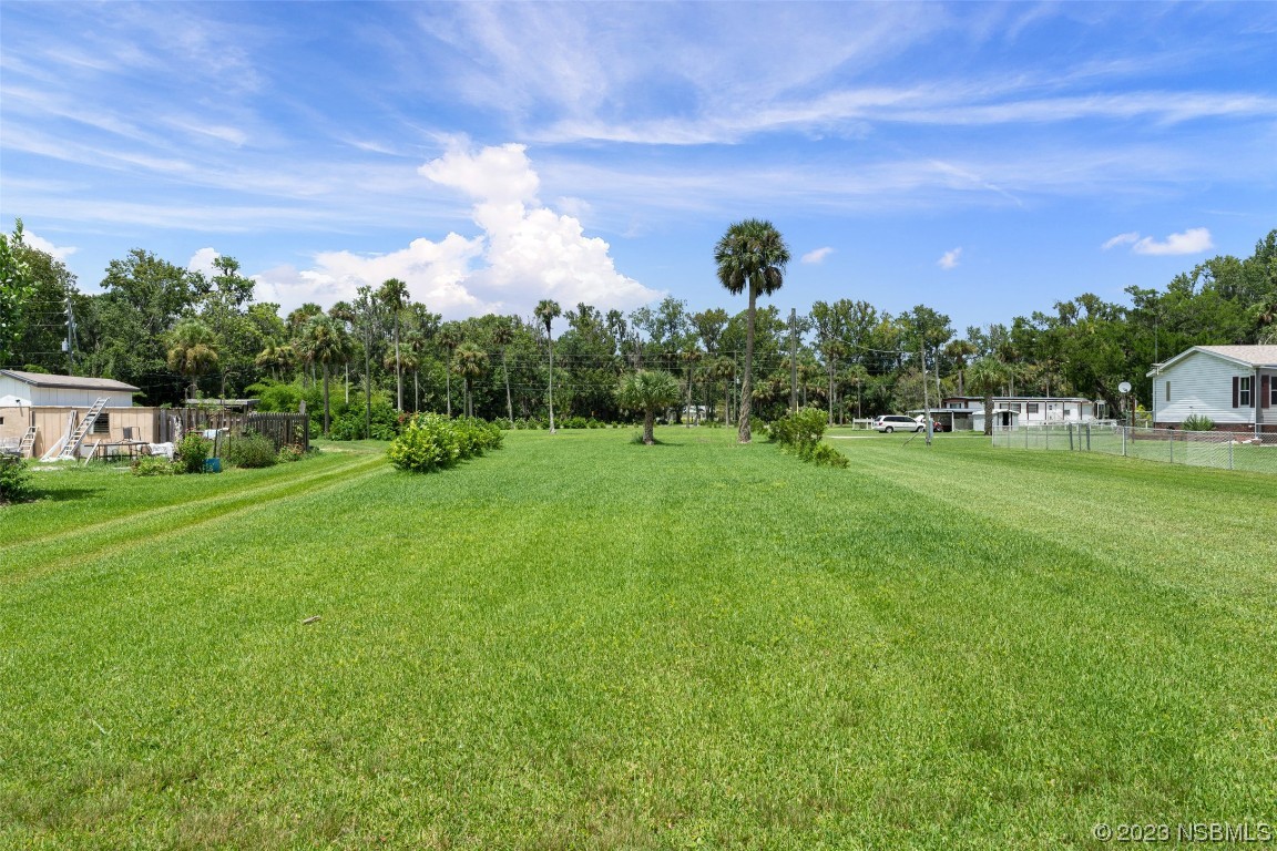 2422 South Taylor Road New Smyrna Beach, FL 32168 - Photo 14 of 19 a backyard of a house with table and chairs