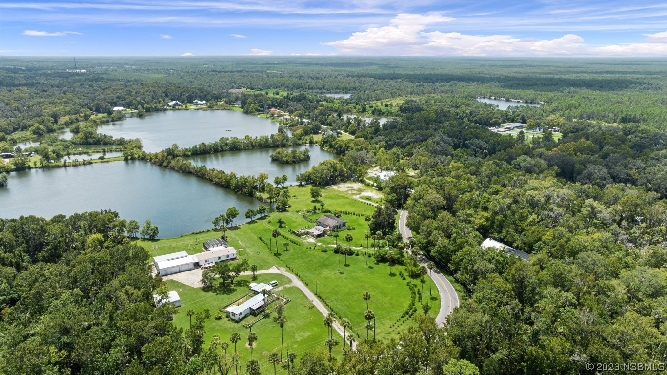 2422 South Taylor Road New Smyrna Beach, FL 32168 - Photo 10 of 19 an aerial view of green landscape with trees houses and lake view