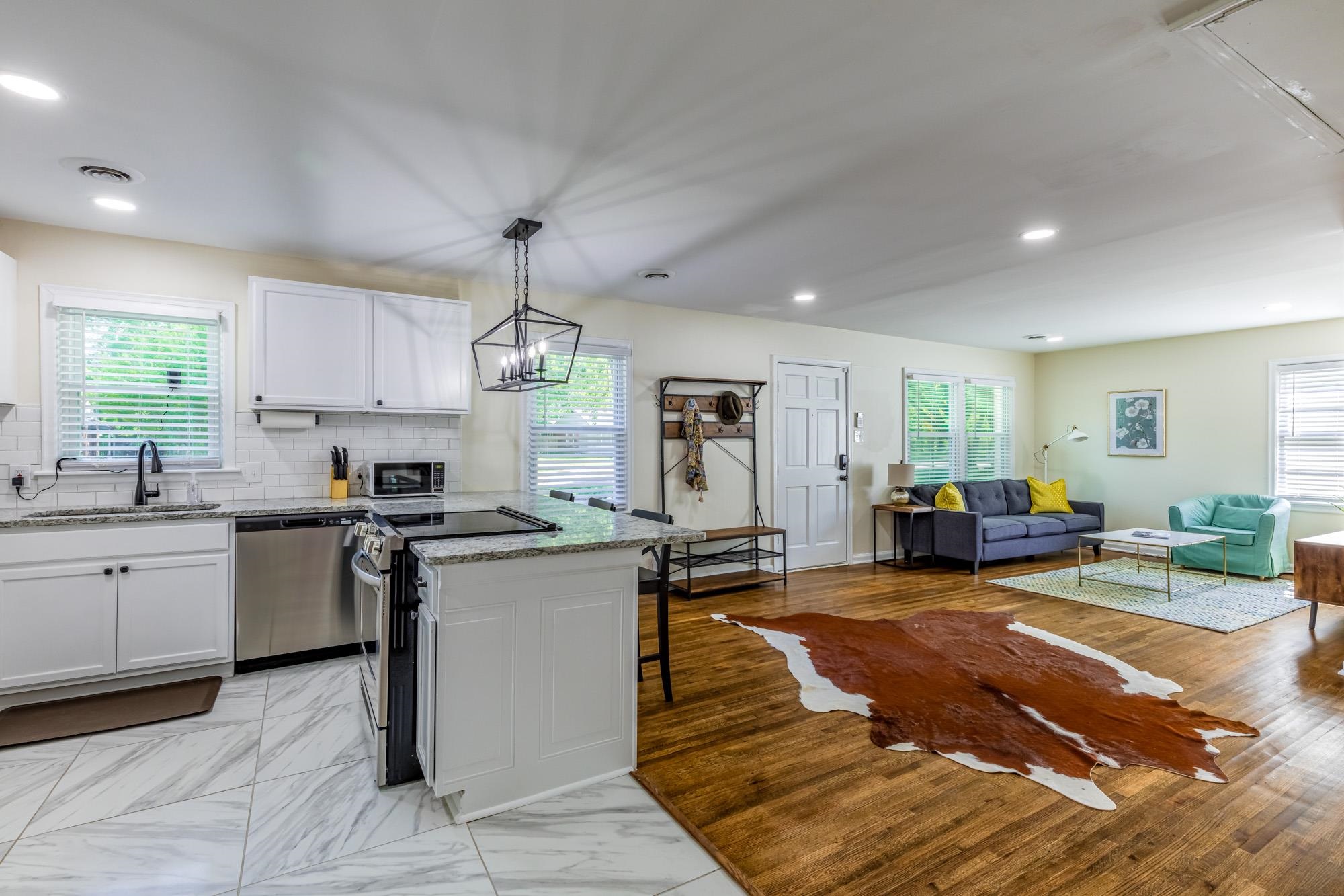 4620 Sea Isle Road Memphis, TN 38117 - Photo 9 of 14 a kitchen with stainless steel appliances granite countertop a stove top oven a sink dishwasher a dining table and chairs with wooden floor