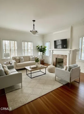 a view of a livingroom with wooden floor and a fireplace
