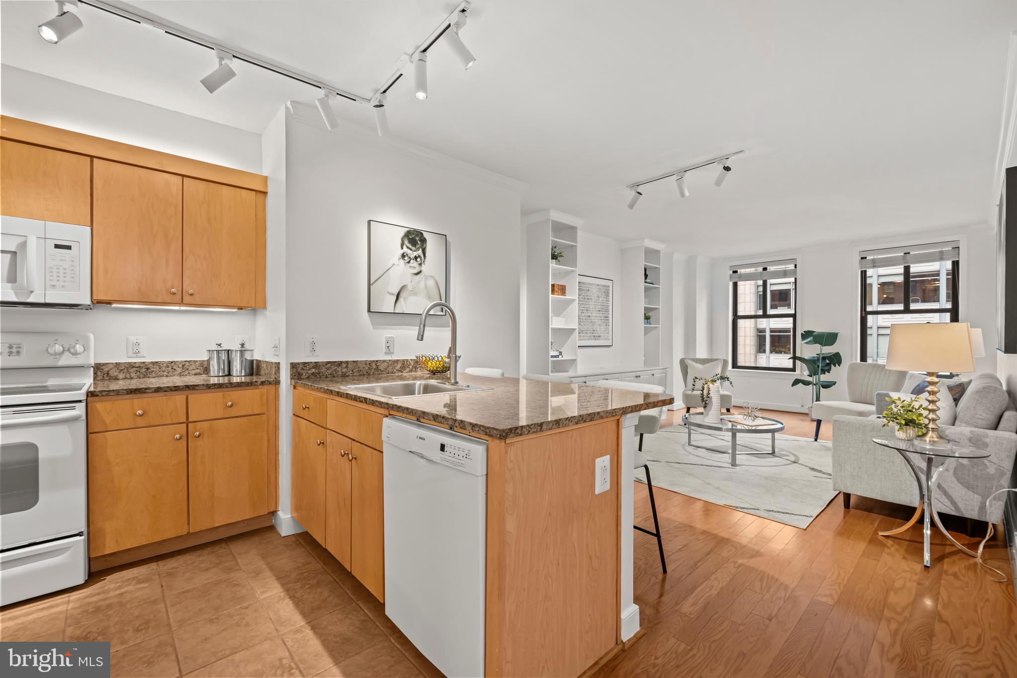 631 D Street Northwest, Unit 632 Washington, DC 20004 - Photo 1 of 78 a open kitchen with stainless steel appliances granite countertop a stove top oven a sink dishwasher and white cabinets with wooden floor