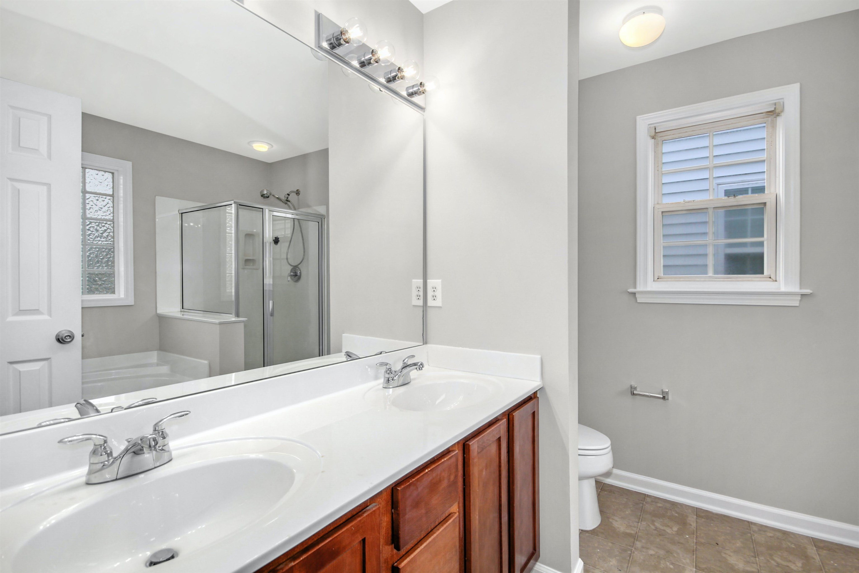 175 Sioux Lane Clayton, NC 27520 - Photo 16 of 26 a bathroom with a sink double vanity granite tub and a mirror
