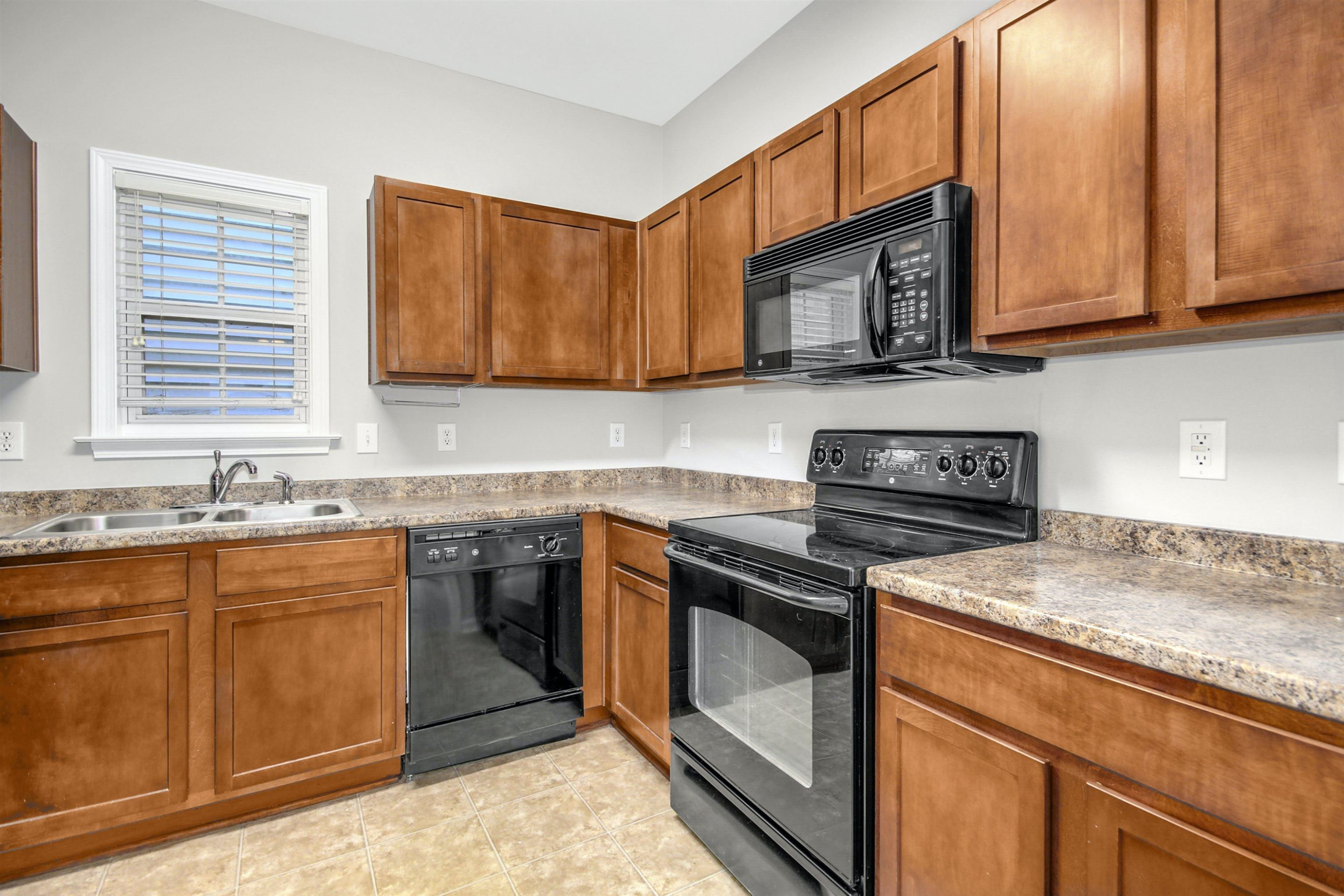 175 Sioux Lane Clayton, NC 27520 - Photo 5 of 26 a kitchen with stainless steel appliances granite countertop a sink stove and microwave
