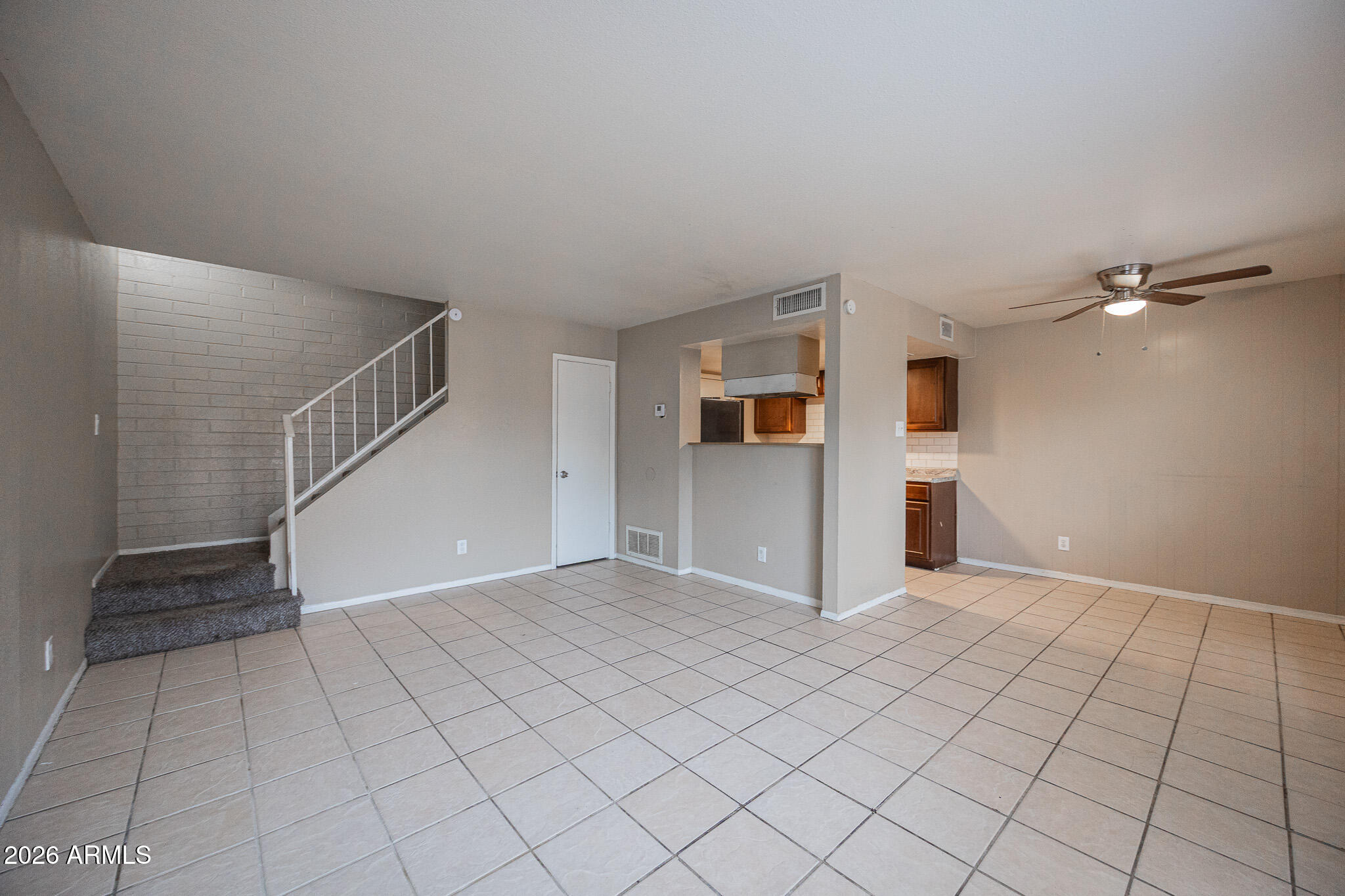 5041 North 39th Lane Phoenix, AZ 85019 - Photo 3 of 15 a view of a livingroom with an empty space and a ceiling fan & window