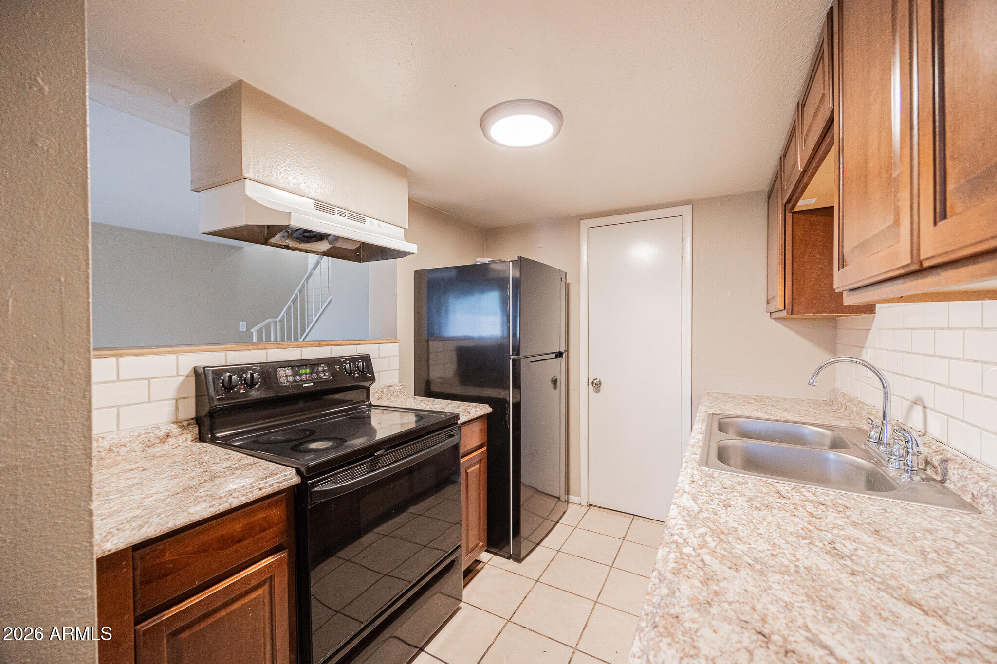 5041 North 39th Lane Phoenix, AZ 85019 - Photo 8 of 15 a kitchen with granite countertop a stove and a sink