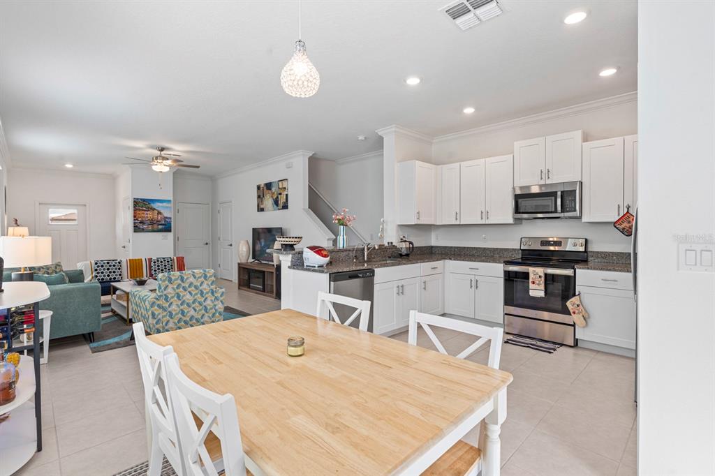 36498 Camp Fire Terrace Zephyrhills, FL 33541 - Photo 13 of 38 a kitchen with stainless steel appliances kitchen island granite countertop a stove and white cabinets