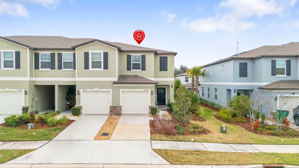 36498 Camp Fire Terrace Zephyrhills, FL 33541 - Photo 2 of 38 a view of a white house with a small yard and plants
