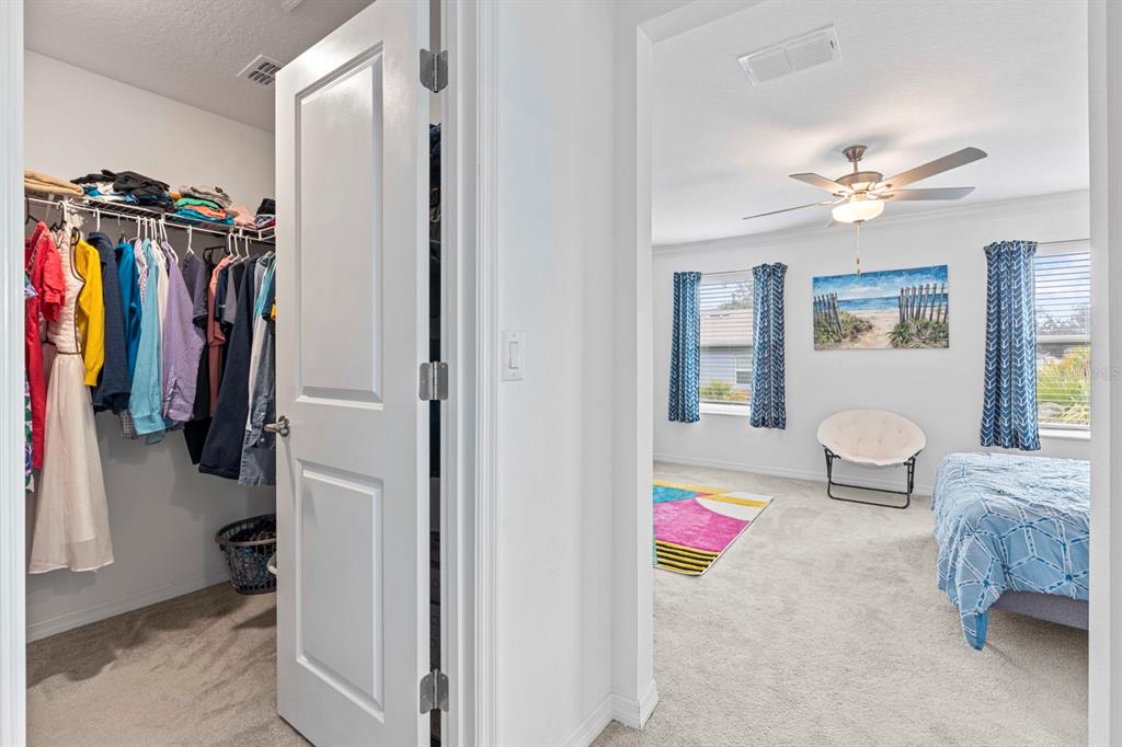 36498 Camp Fire Terrace Zephyrhills, FL 33541 - Photo 21 of 38 a bedroom with a bed and a chandelier