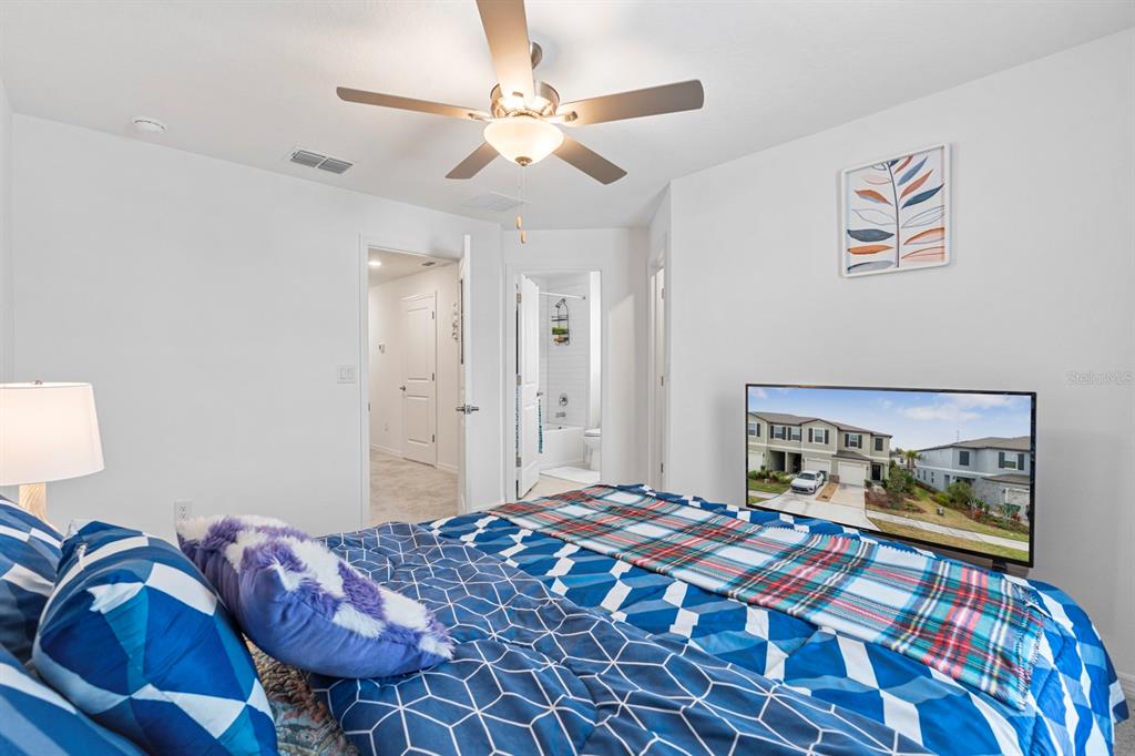 36498 Camp Fire Terrace Zephyrhills, FL 33541 - Photo 23 of 38 a bedroom with a bed and a chandelier