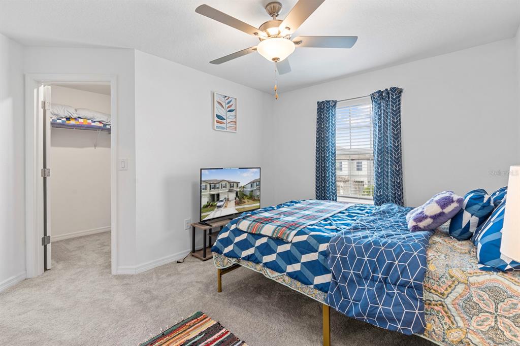 36498 Camp Fire Terrace Zephyrhills, FL 33541 - Photo 24 of 38 a bedroom with a bed and a chandelier