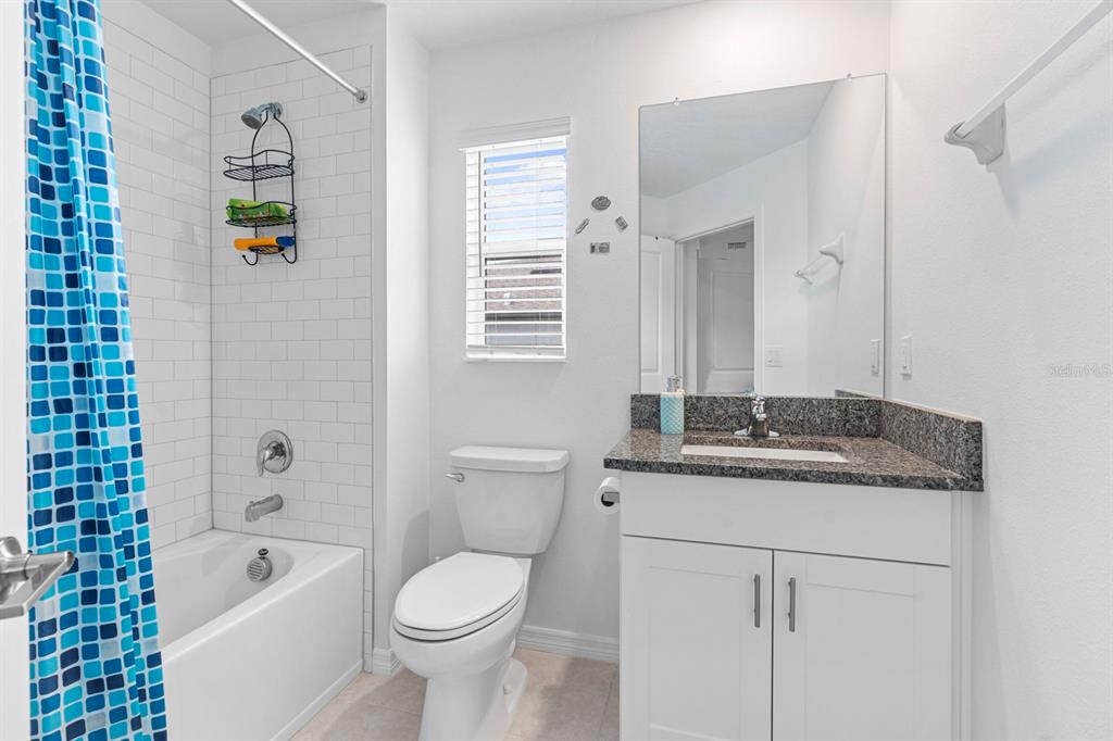 36498 Camp Fire Terrace Zephyrhills, FL 33541 - Photo 25 of 38 a bathroom with a granite countertop toilet sink and mirror