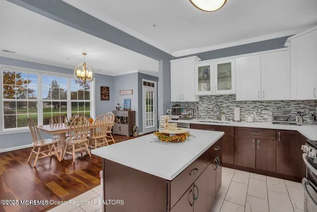 a kitchen with a dining table chairs and stove top oven
