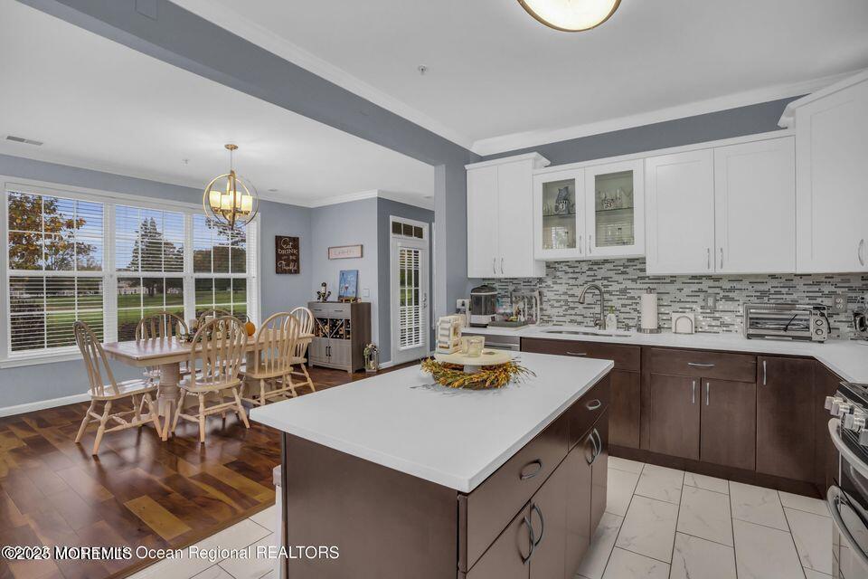 410 St Andrews Place Manalapan, NJ 07726 - Photo 13 of 23 a kitchen with a dining table chairs and stove top oven