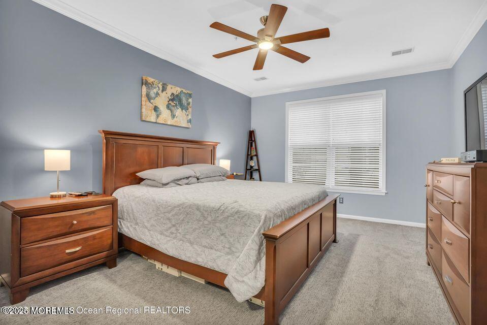 410 St Andrews Place Manalapan, NJ 07726 - Photo 16 of 23 a bedroom with a bed and a chandelier