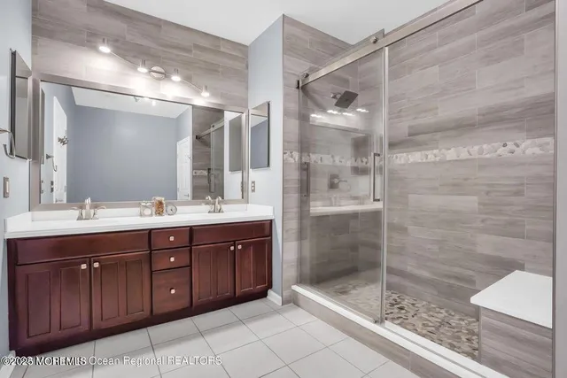 a bathroom with a shower sink vanity and mirror