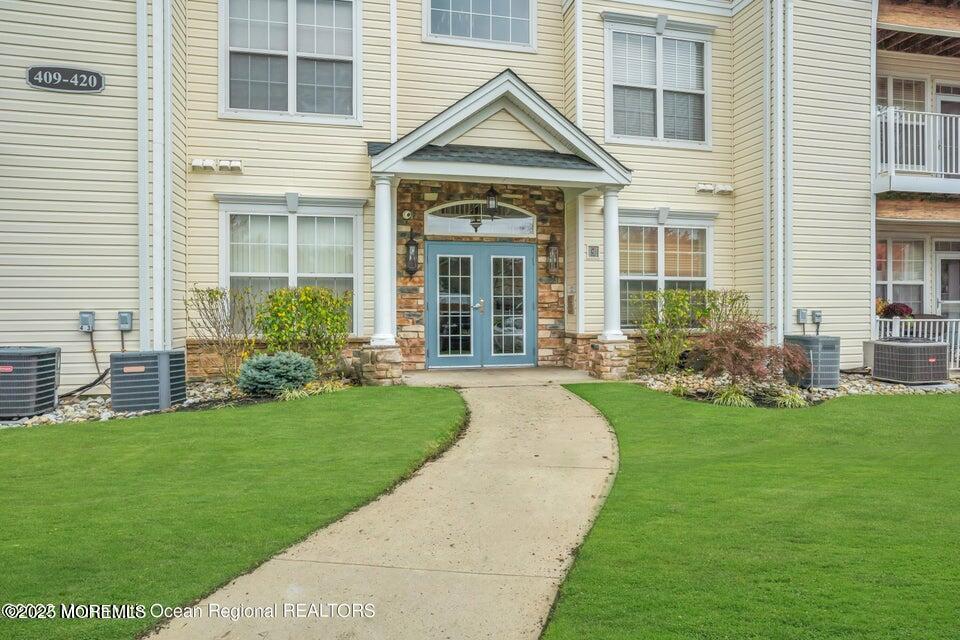 410 St Andrews Place Manalapan, NJ 07726 - Photo 2 of 23 a front view of a house with garden