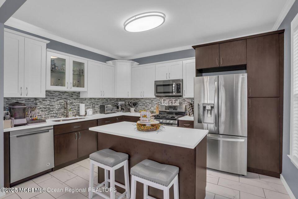 410 St Andrews Place Manalapan, NJ 07726 - Photo 10 of 23 a kitchen with a sink a stove cabinets and refrigerator