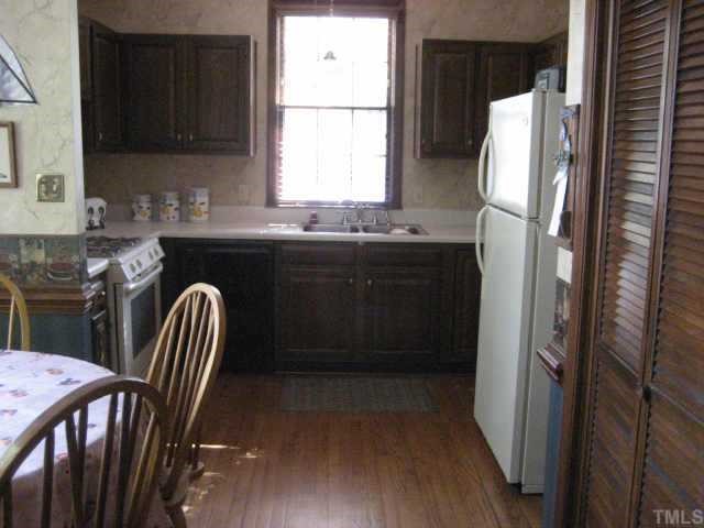 913 Albany Court Raleigh, NC 27615 - Photo 2 of 10 a kitchen with stainless steel appliances granite countertop a refrigerator a sink a stove a dining table and chairs
