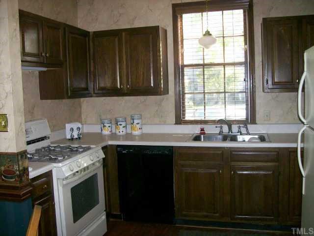 913 Albany Court Raleigh, NC 27615 - Photo 3 of 10 a kitchen with granite countertop a sink stove and cabinets