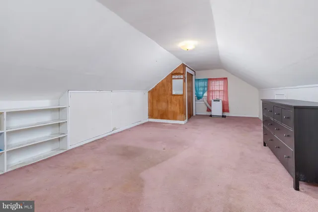 a view of an empty room with a fireplace and a window