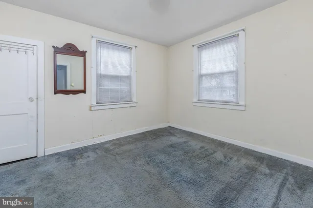 an empty room with windows and closet