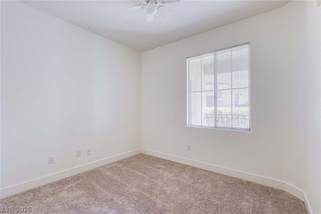 9050 West Warm Springs Road, Unit 1011 Las Vegas, NV 89148 - Photo 13 of 32 An inviting secondary bedroom featuring plush carpeting and a modern ceiling fan.