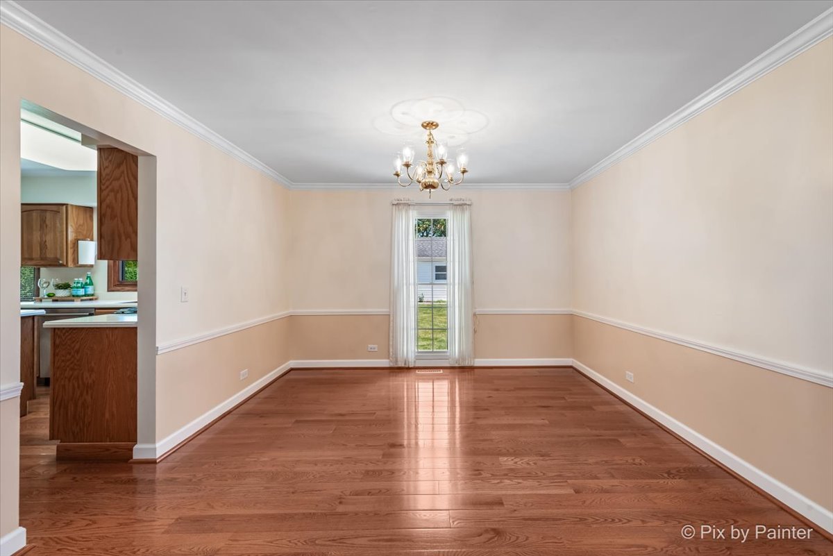 1599 Burning Trail Wheaton, IL 60189 - Photo 10 of 64 an empty room with wooden floor chandelier and windows