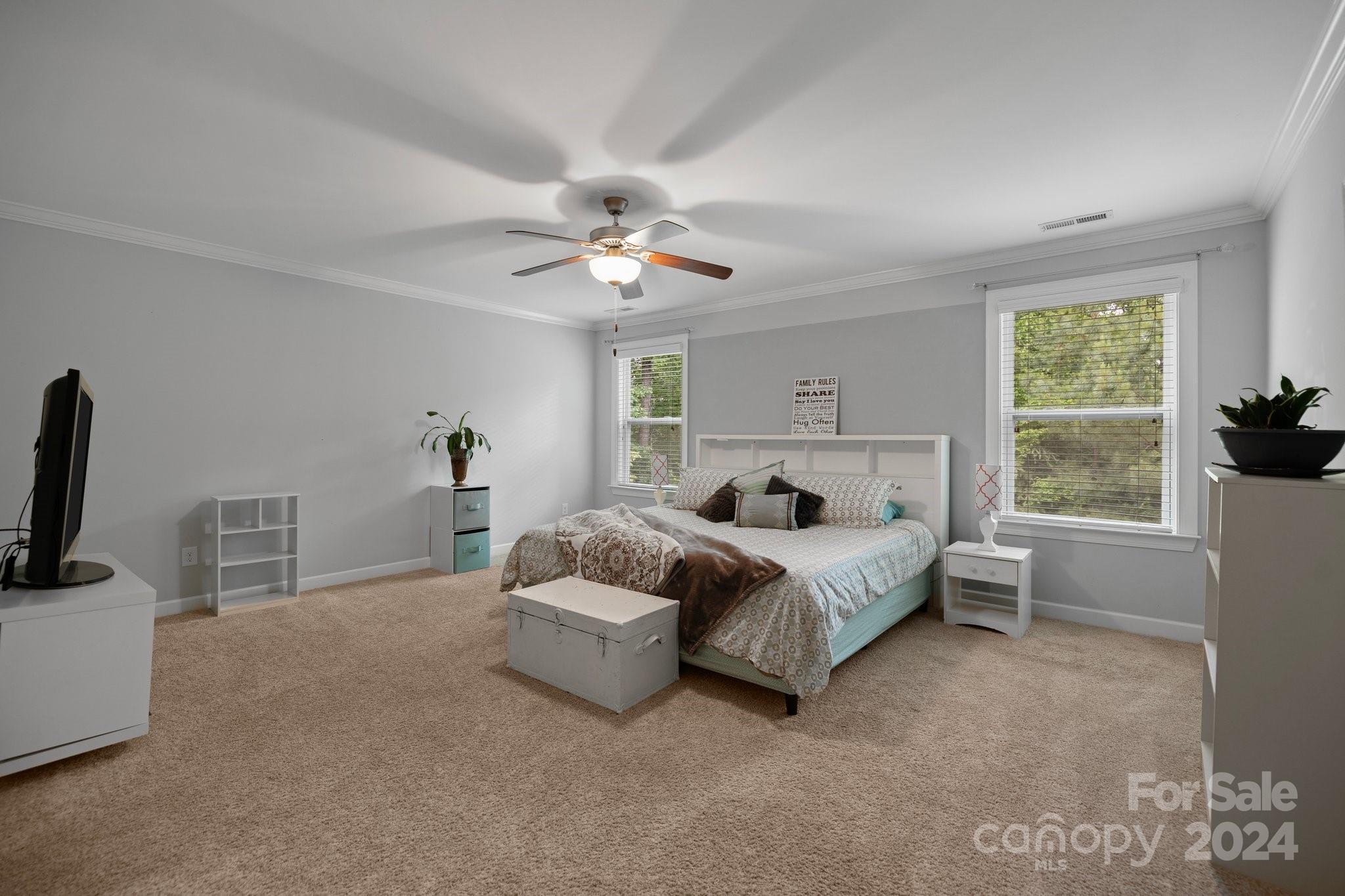 2061 Fuschia Court Fort Mill, SC 29708 - Photo 17 of 45 a spacious bedroom with a bed a couch and a flat tv screen on the dresser