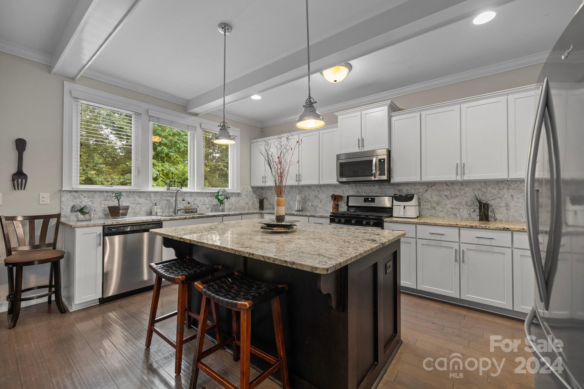 2061 Fuschia Court Fort Mill, SC 29708 - Photo 6 of 45 a kitchen with a stove a sink a microwave a dining table and chairs