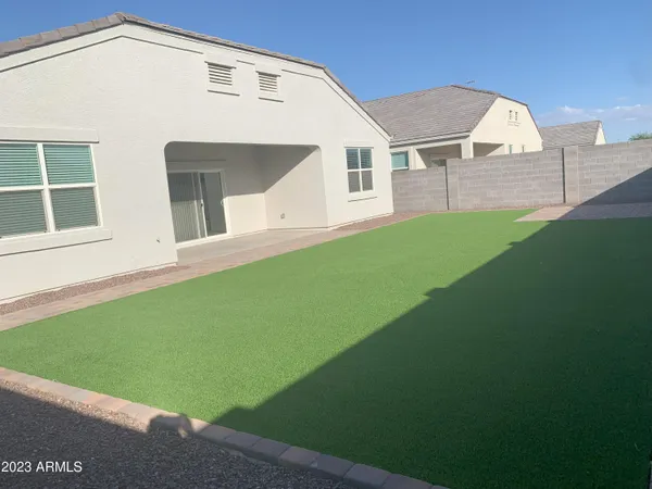 a view of an house with backyard space and balcony