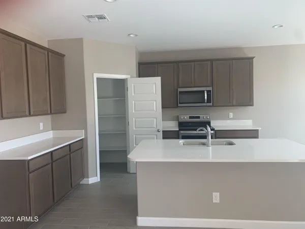 a kitchen with a sink a microwave a refrigerator and cabinets