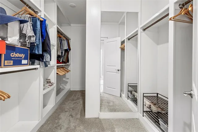 a view of walk in closet with clothes and shoes