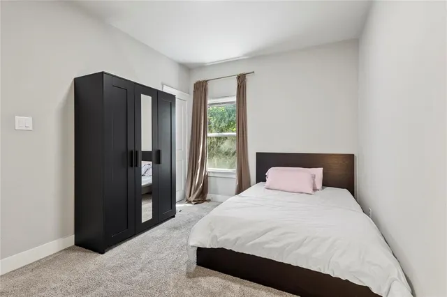 a large bed in a bedroom next to a window