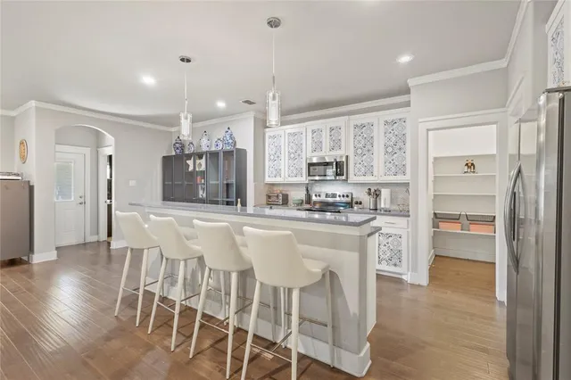 a kitchen with stainless steel appliances granite countertop a refrigerator and a stove top oven