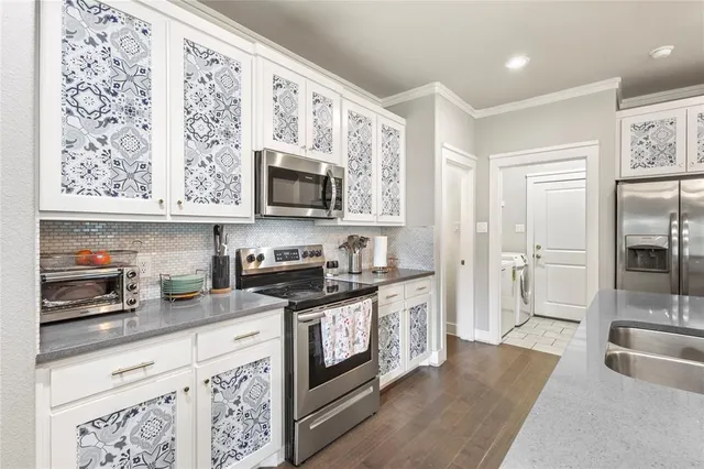 a kitchen with stainless steel appliances granite countertop a stove a sink and a microwave