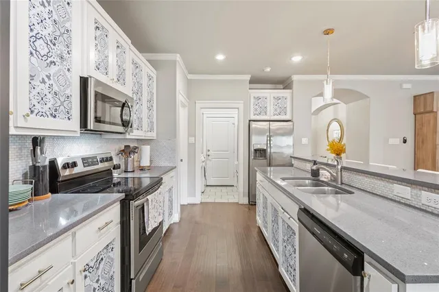 a kitchen with stainless steel appliances granite countertop a sink stove and refrigerator
