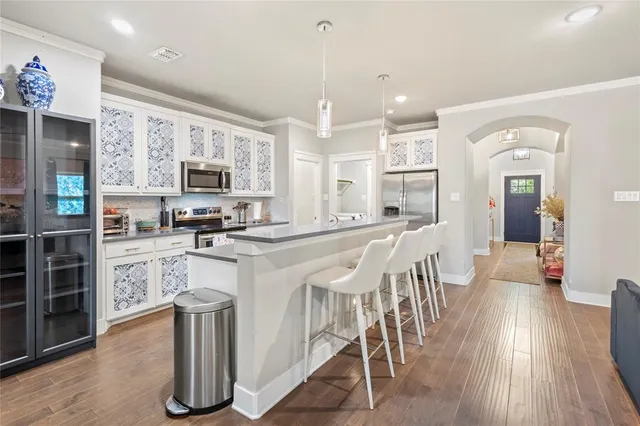 a large kitchen with white cabinets and stainless steel appliances
