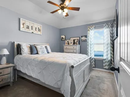a bedroom with a bed and a flat tv screen on dresser