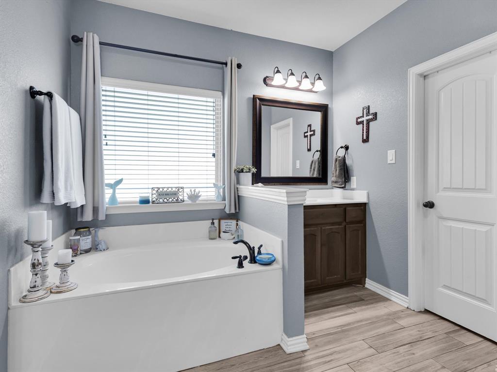 128 County Road 4430 Decatur, TX 76234 - Photo 20 of 34 a bathroom with a tub sink and mirror