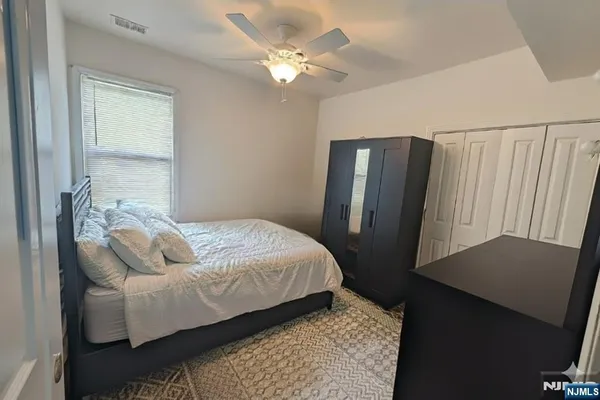 a bedroom with a bed dresser and a window