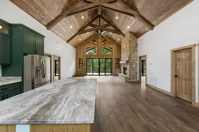 an empty room with wooden floor fireplace and windows