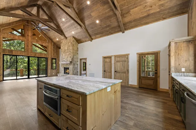 a kitchen with a stove and a granite counter tops with large windows
