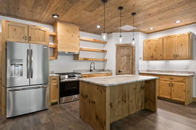 a kitchen with cabinets wooden floor and stainless steel appliances