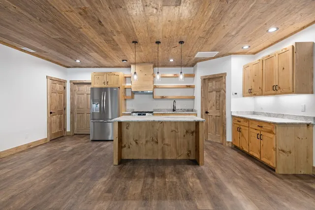 a kitchen with stainless steel appliances granite countertop a sink a stove and a refrigerator