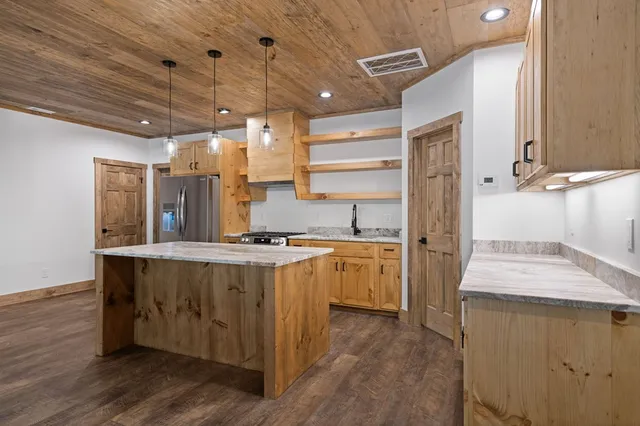 a kitchen with kitchen island a sink stove and wooden floor