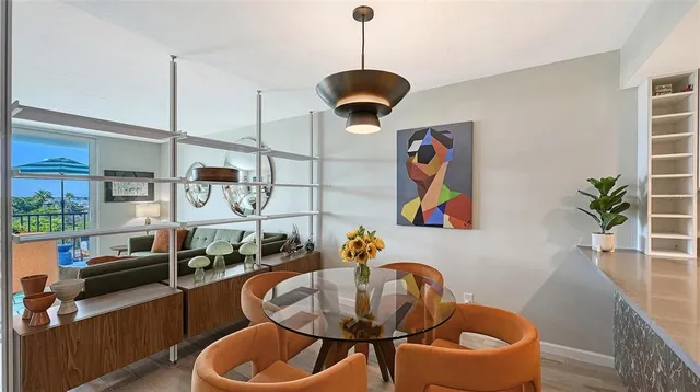 a view of a dining room and livingroom with furniture wooden floor a chandelier