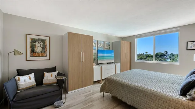 a bedroom with a bed and a potted plant