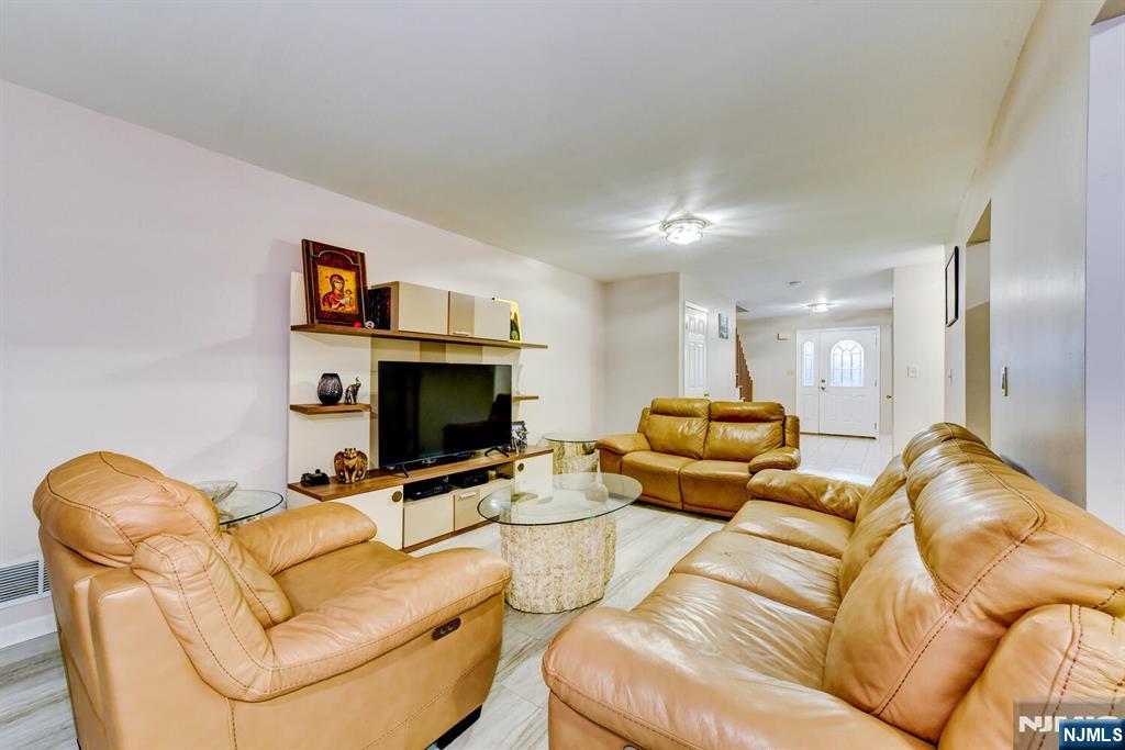 6 Hansen Place, Unit 6 Wayne, NJ 07470 - Photo 19 of 49 a living room with furniture and a flat screen tv