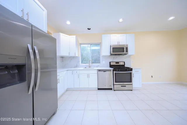 a kitchen with stainless steel appliances granite countertop a refrigerator sink and stove