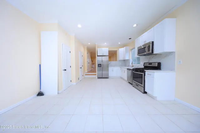 a open kitchen with stainless steel appliances granite countertop a refrigerator oven a sink and dishwasher